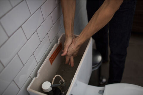 Hands collecting water from a toilet tank, photographed for the NYT during Puerto Rico's drought rationing